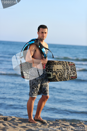 Image of Portrait of a young  kitsurf  man at beach on sunset