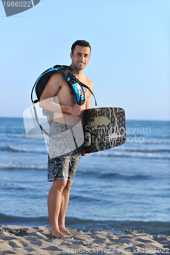 Image of Portrait of a young  kitsurf  man at beach on sunset