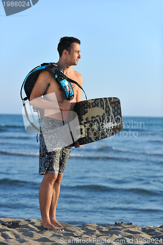 Image of Portrait of a young  kitsurf  man at beach on sunset