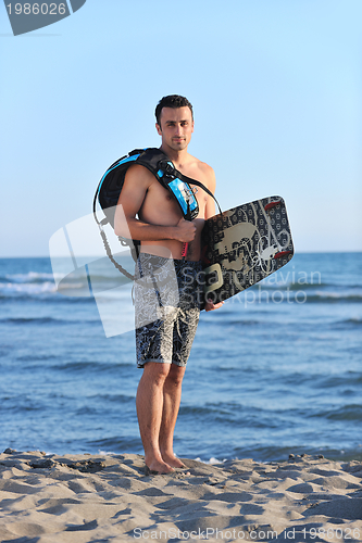 Image of Portrait of a young  kitsurf  man at beach on sunset