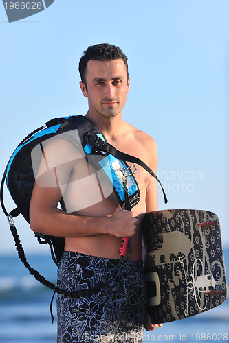 Image of Portrait of a young  kitsurf  man at beach on sunset