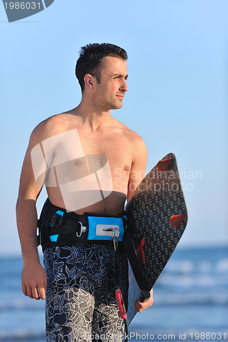 Image of Portrait of a young  kitsurf  man at beach on sunset
