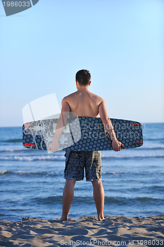 Image of Portrait of a young  kitsurf  man at beach on sunset
