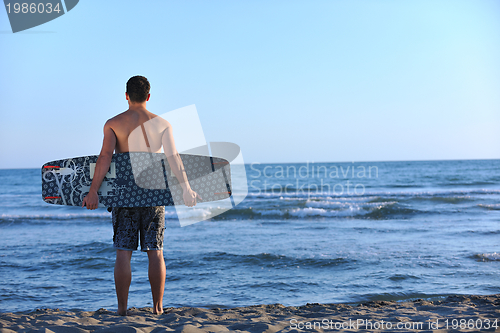 Image of Portrait of a young  kitsurf  man at beach on sunset