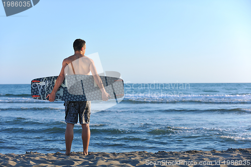 Image of Portrait of a young  kitsurf  man at beach on sunset