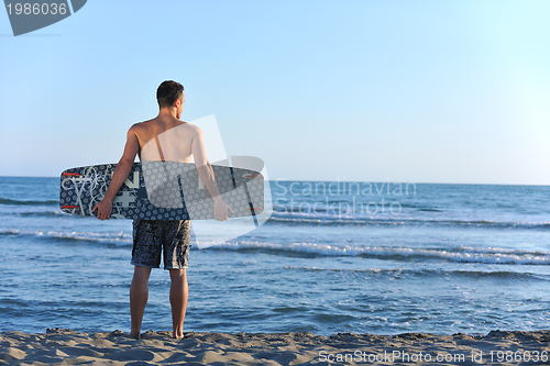 Image of Portrait of a young  kitsurf  man at beach on sunset