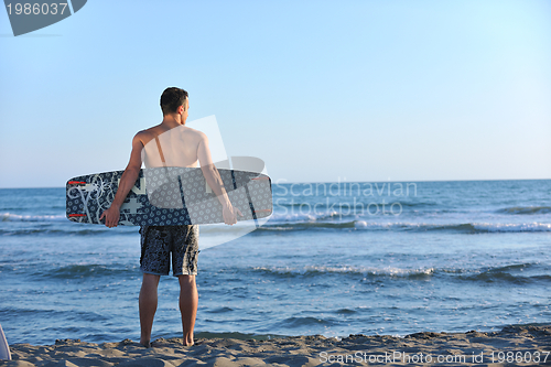 Image of Portrait of a young  kitsurf  man at beach on sunset