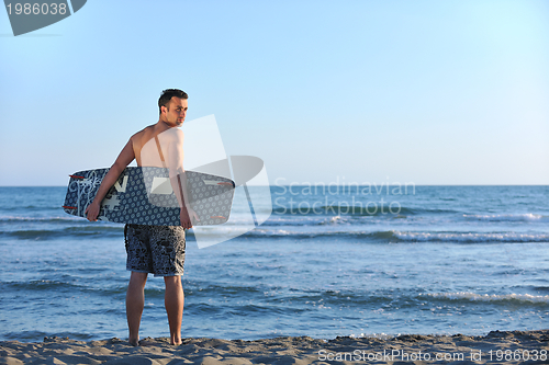 Image of Portrait of a young  kitsurf  man at beach on sunset