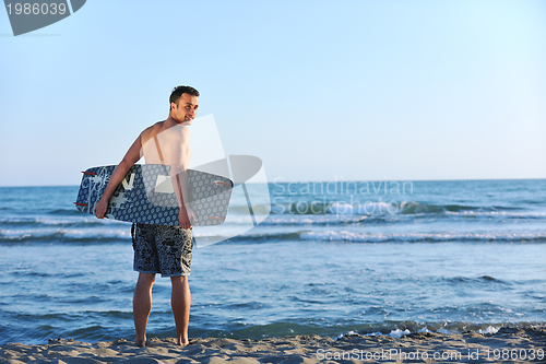 Image of Portrait of a young  kitsurf  man at beach on sunset