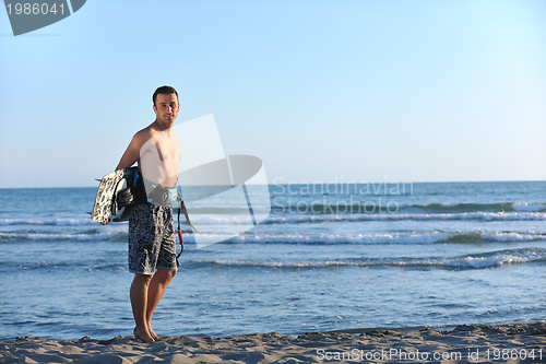 Image of Portrait of a young  kitsurf  man at beach on sunset