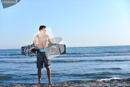 Image of Portrait of a young  kitsurf  man at beach on sunset