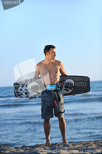 Image of Portrait of a young  kitsurf  man at beach on sunset