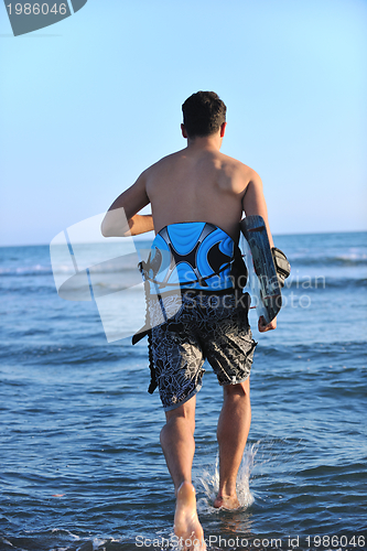 Image of Portrait of a young  kitsurf  man at beach on sunset