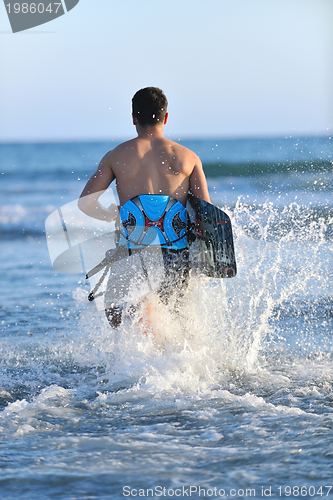 Image of Portrait of a young  kitsurf  man at beach on sunset