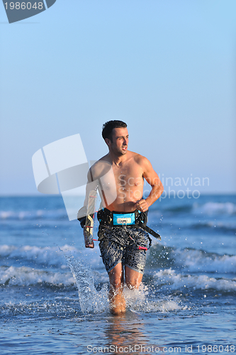 Image of Portrait of a young  kitsurf  man at beach on sunset