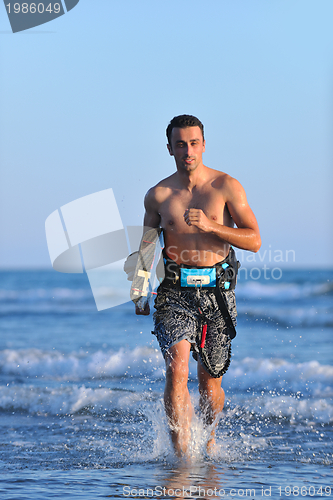 Image of Portrait of a young  kitsurf  man at beach on sunset
