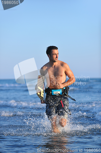 Image of Portrait of a young  kitsurf  man at beach on sunset