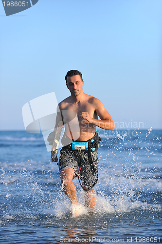 Image of Portrait of a young  kitsurf  man at beach on sunset