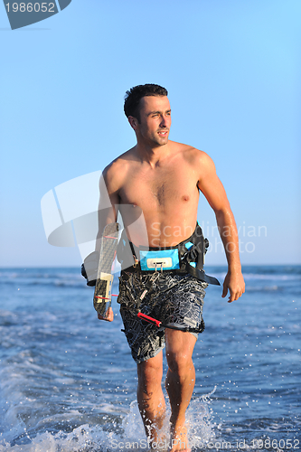 Image of Portrait of a young  kitsurf  man at beach on sunset