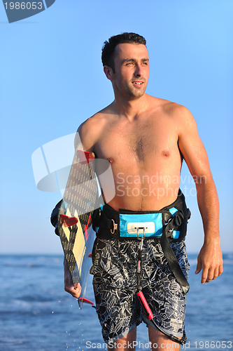 Image of Portrait of a young  kitsurf  man at beach on sunset