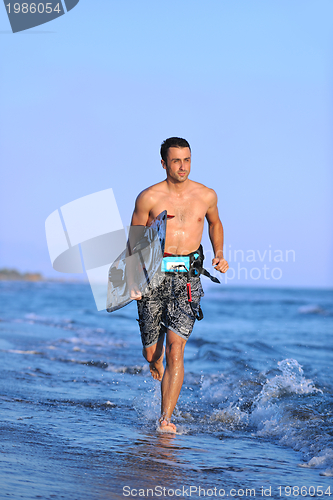 Image of Portrait of a young  kitsurf  man at beach on sunset