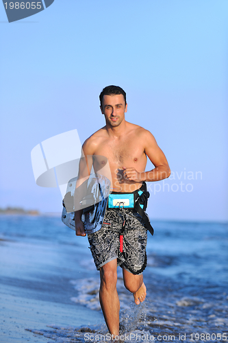 Image of Portrait of a young  kitsurf  man at beach on sunset