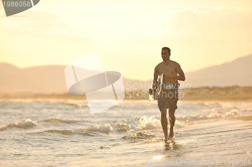 Image of Portrait of a young  kitsurf  man at beach on sunset