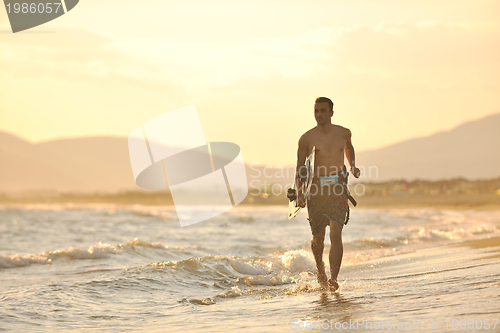 Image of Portrait of a young  kitsurf  man at beach on sunset