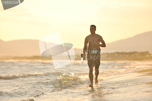 Image of Portrait of a young  kitsurf  man at beach on sunset