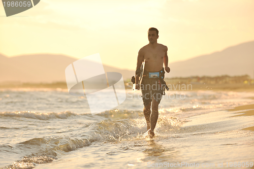Image of Portrait of a young  kitsurf  man at beach on sunset