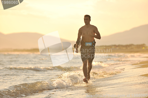 Image of Portrait of a young  kitsurf  man at beach on sunset