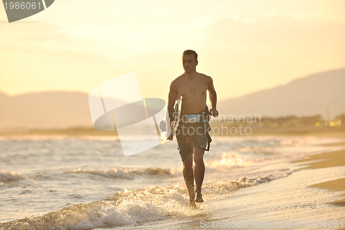 Image of Portrait of a young  kitsurf  man at beach on sunset