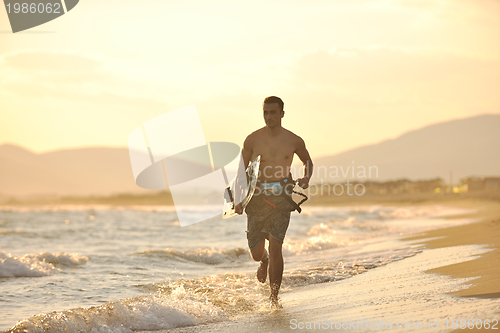 Image of Portrait of a young  kitsurf  man at beach on sunset