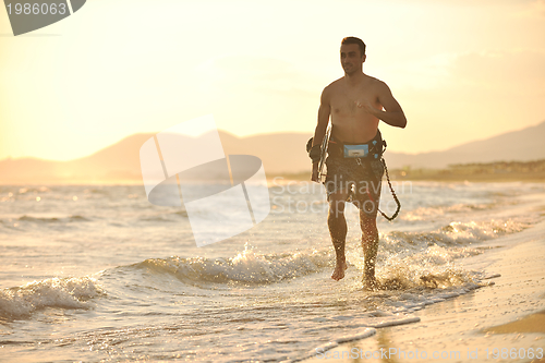 Image of Portrait of a young  kitsurf  man at beach on sunset