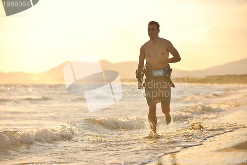 Image of Portrait of a young  kitsurf  man at beach on sunset