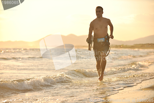 Image of Portrait of a young  kitsurf  man at beach on sunset