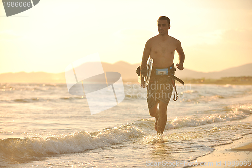 Image of Portrait of a young  kitsurf  man at beach on sunset