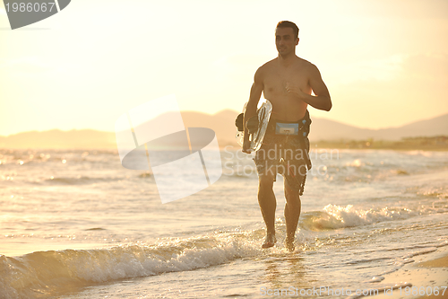 Image of Portrait of a young  kitsurf  man at beach on sunset