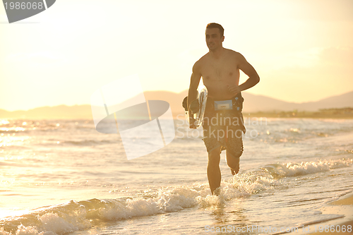 Image of Portrait of a young  kitsurf  man at beach on sunset