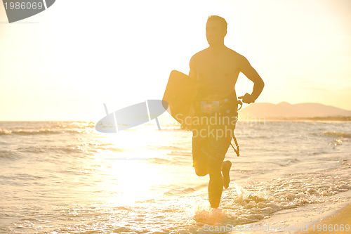 Image of Portrait of a young  kitsurf  man at beach on sunset