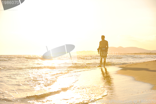 Image of Portrait of a young  kitsurf  man at beach on sunset