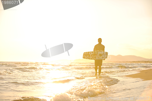 Image of Portrait of a young  kitsurf  man at beach on sunset