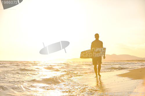 Image of Portrait of a young  kitsurf  man at beach on sunset
