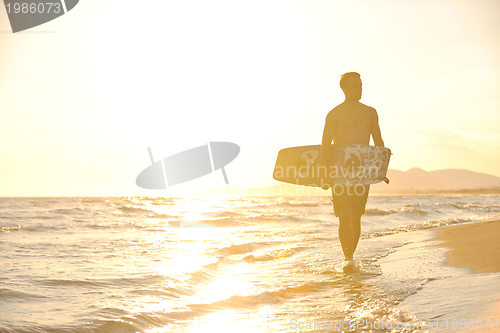 Image of Portrait of a young  kitsurf  man at beach on sunset