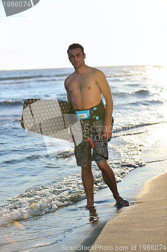 Image of Portrait of a young  kitsurf  man at beach on sunset