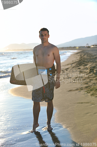 Image of Portrait of a young  kitsurf  man at beach on sunset