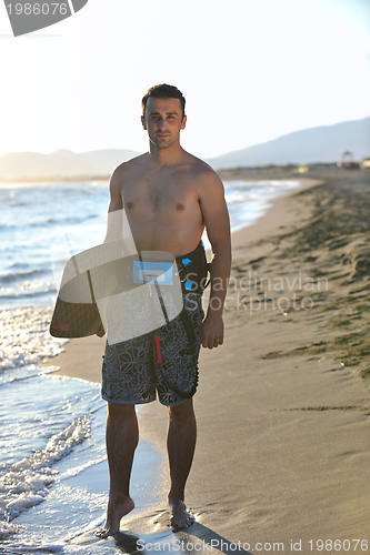 Image of Portrait of a young  kitsurf  man at beach on sunset