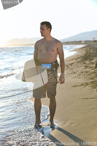 Image of Portrait of a young  kitsurf  man at beach on sunset