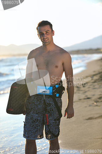 Image of Portrait of a young  kitsurf  man at beach on sunset