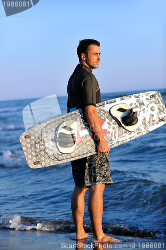 Image of Portrait of a young  kitsurf  man at beach on sunset